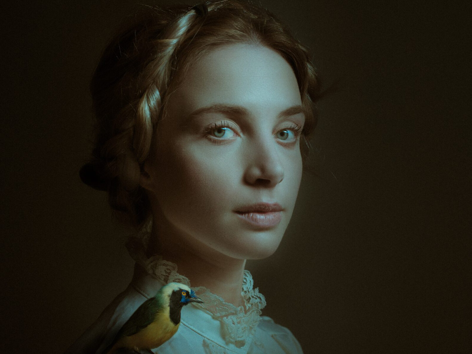 Un tirage d'un photographe client : portrait de studio, une jeune femme et un oiseau posé sur son épaule